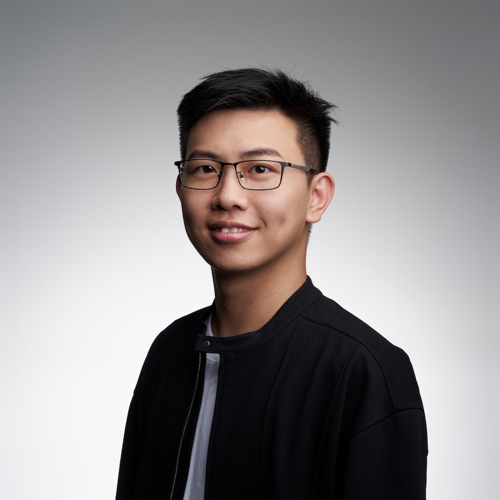Official photo of Ziren Zhou, also known as Steven Zhou, with a light gray background, wearing a black jacket, glasses, and smiling at the camera.